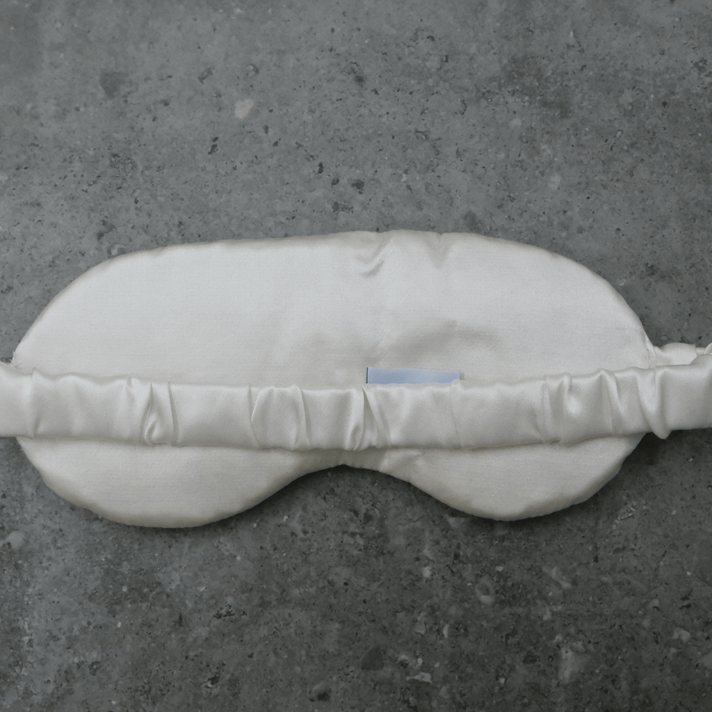 Back of silk eye sleeping mask on a dark background